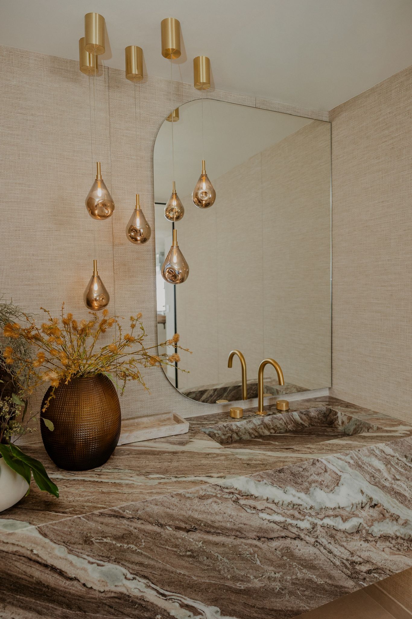 Living room corner with brass lamp and ceramic vessel.